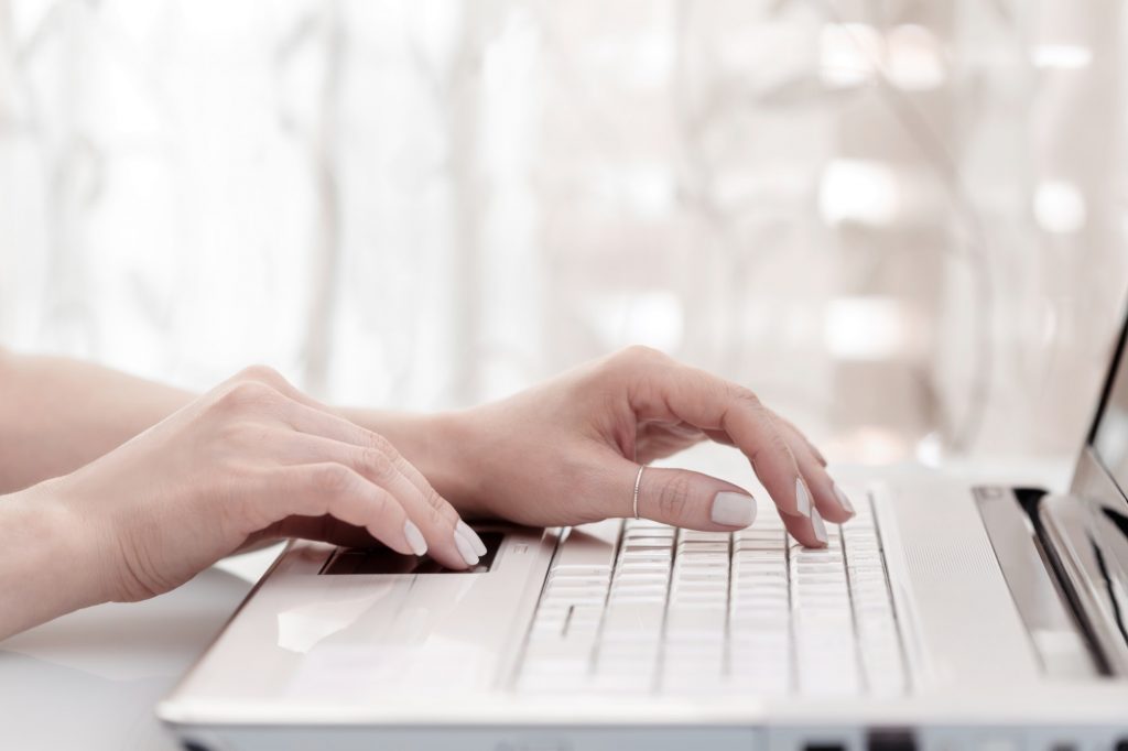 Blogger or business woman typing on laptop